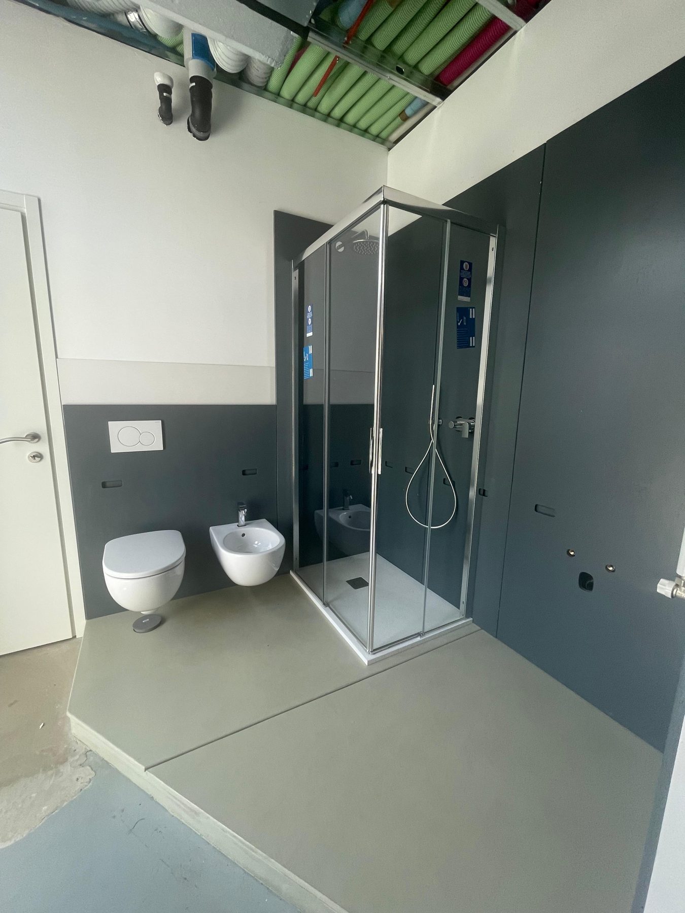 Bagno completo con doccia, sanitari sospesi e termoarredo