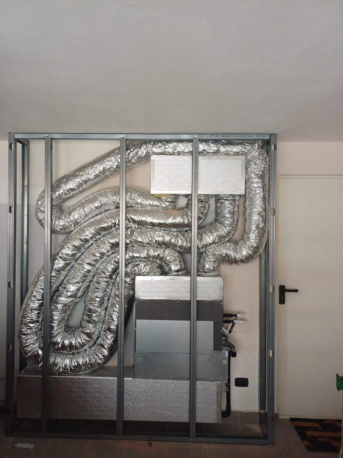 Unità VMC e condotti flessibili isolati dentro un telaio metallico, prima di chiudere la parete